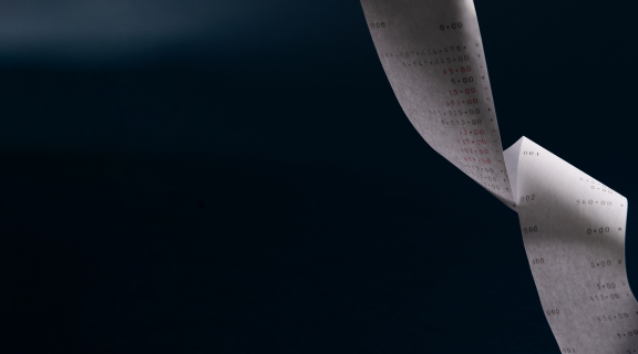 Valkoinen pitkä kuitti mustaa taustaa vasten.