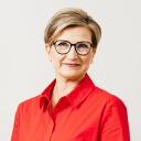 Valkoihoinen nainen punaisessa paidassa.