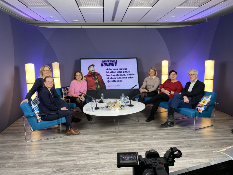 Studiossa sohvaryhmällä istumassa kuusi henkilöä.