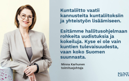 Nainen bleiserissä hymyilee.